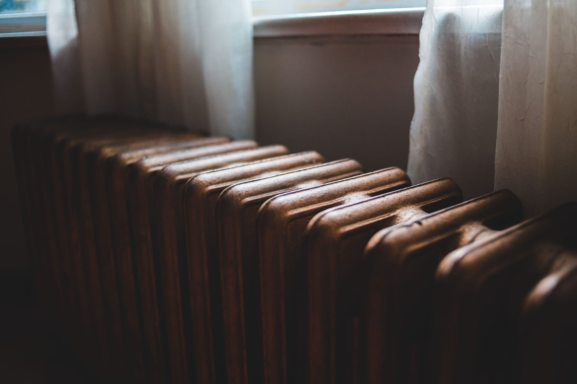 Cast iron column radiator beneath a single-glazed window